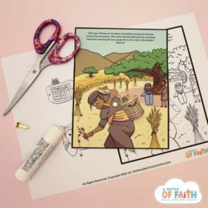 Finished Ruth and Boaz craft shown on top of of printable template with scissors and glue stick